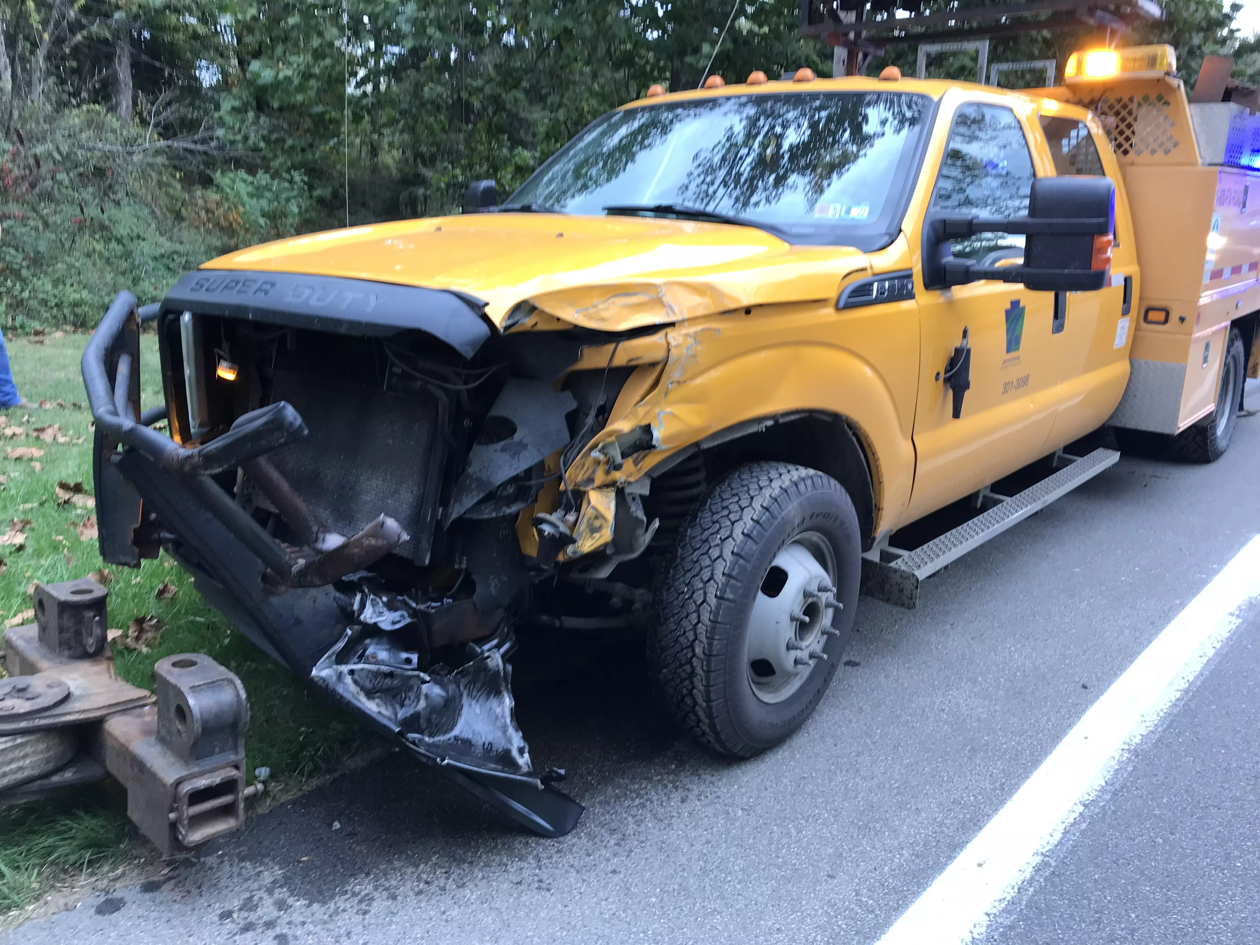 An image of a yellow PennDOT crew cab pickup truck with a damaged front end.